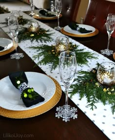 a table set for christmas dinner with place settings