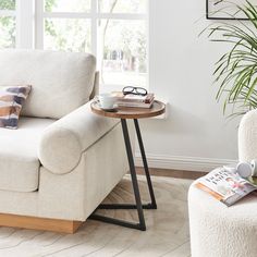 a living room with a couch, chair and coffee table in front of a window