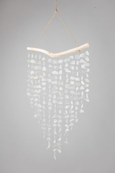 a wind chime hanging from a rope on a gray wall