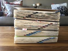 a stack of papers sitting on top of a wooden table