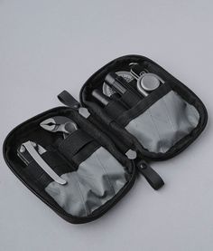 two zippered pouches with scissors and other items in them on a white surface