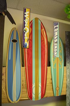 three surfboards are hanging on the wall