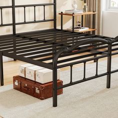 a black metal bed frame sitting on top of a carpeted floor next to a window