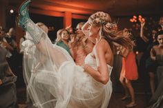 a woman in a white dress dancing with other people