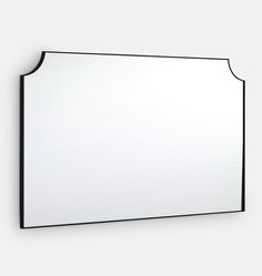 a white mirror hanging on the wall next to a black frame with an arched edge