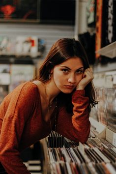 a woman leaning on a shelf in a record store