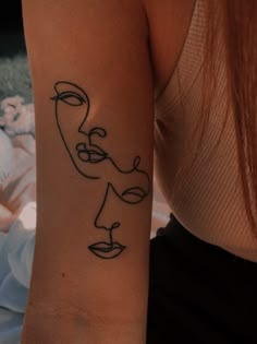 a woman's arm with a black line drawing of a face on the wrist