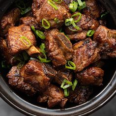 a bowl filled with meat and green onions