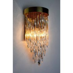 a wall light that is on the side of a wall with crystal beads hanging from it