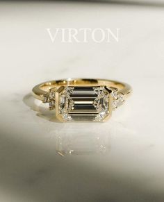 a gold ring with an emerald cut diamond