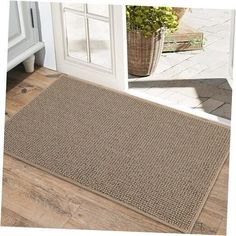 a door mat that is on the floor next to a potted plant in front of an open door