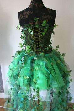 a dress made out of green leaves on top of a mannequin