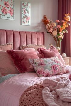 a bed with pink sheets and pillows in a bedroom