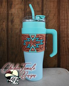 a blue coffee cup with a turquoise lid and handle is next to a wooden wall