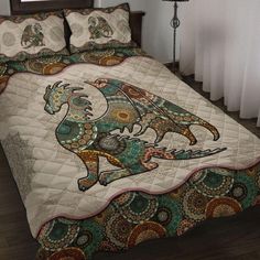 a bed covered in a colorful comforter and pillows