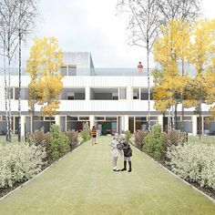 two people standing in front of a building with trees and bushes on the side walk