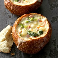 two bread bowls filled with broccoli and cheese