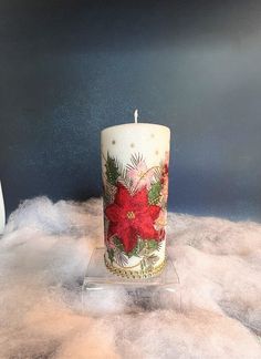 a white candle with red poinsettia on it