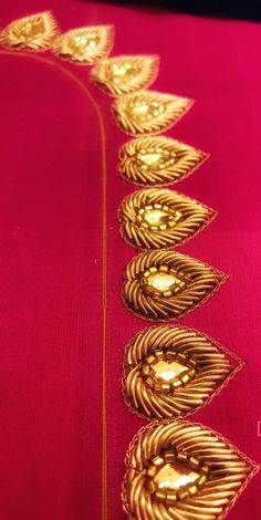 the gold thread is on top of the red cloth, which has been stitched together