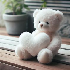 a white teddy bear sitting on top of a wooden table next to a potted plant