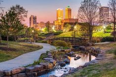 a river running through a park next to tall buildings