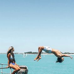 two people diving into the ocean from a boat