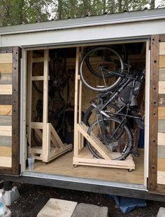 the inside of a storage shed with bicycles in it's door and one bicycle mounted to the side of the building