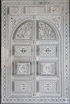 an intricately carved white door on display