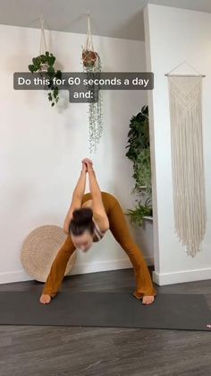 a woman is doing yoga in front of a wall with plants on it and the caption reads do this for 60 seconds a day and