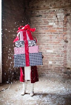 a person standing in front of a brick wall with a wrapped present on it's back