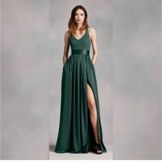 a woman in a long green dress posing for the camera