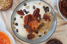 a bowl filled with yogurt, granola and nuts