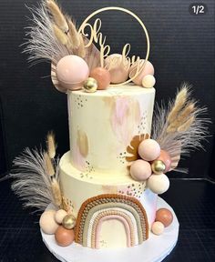 a three tiered cake decorated with feathers, eggs and other decorations on a table