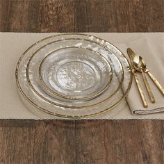 there is a place setting on the table with goldware and utensils in it