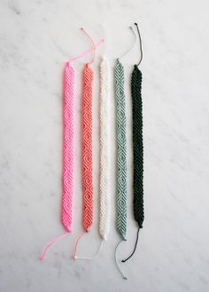 three different colored hair ties on a white surface