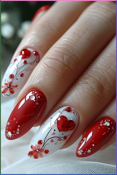 a woman's hand with red and white nail polish on her nails, decorated with flowers