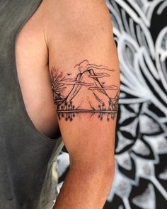 a man with a mountain tattoo on his arm