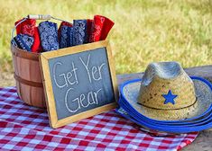 a cowboy hat sitting on top of a table next to a sign that says get your gear