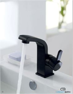 a black faucet running water from it's spout in a bathroom