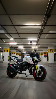 a white and black motorcycle parked in a parking garage