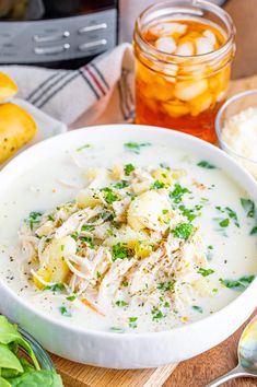 a white bowl filled with soup next to some bread and other food on a table