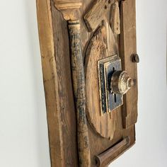 an old wooden door with a lock on the front and side panel is hanging on a wall