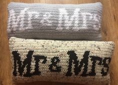 two knitted pillows sitting on top of a wooden floor with the words welcome written on them