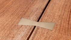 a piece of metal sitting on top of a wooden table next to another piece of wood