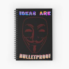 a spiral notebook with the words ideas are bulletproof written on it and an image of a mask