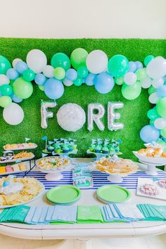 a table topped with lots of food and balloons