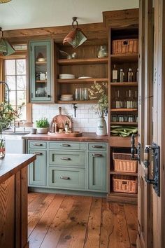 an open kitchen with wooden floors and green cabinetry, along with baskets on the counter