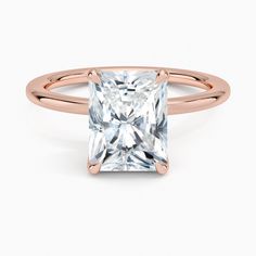 a rose gold ring with a princess cut diamond in the center and an accent band