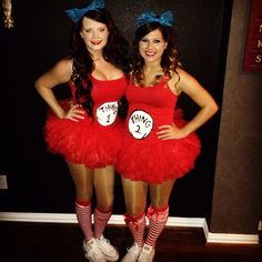 two women dressed in red dresses and cat in the hat costumes pose for a photo