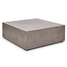 a square concrete coffee table sitting on top of a white floor